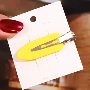 Detail shot of a 6cm yellow acetate hair clip on wood background with size marking