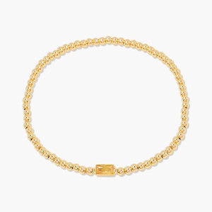 Bracelet minimaliste en perles dorées avec une pierre de naissance jaune centrale