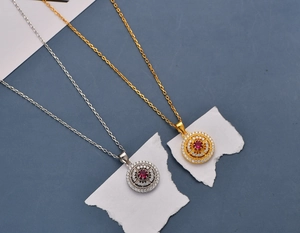 Detailed macro view of gold and silver necklaces with red gemstone and pavé diamonds