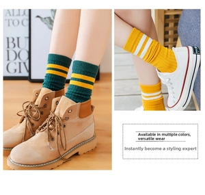 Detail of knit cotton mid-calf striped socks paired with boots and sneakers in autumn style