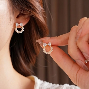Elegante goldene Schleifenohrringe mit Zirkonia und weißen Perlen im französischen Stil