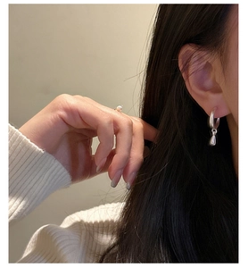 Close-up of S925 silver water drop earrings and pearl ring on model for a sleek look