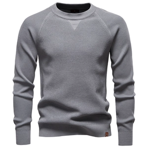 Detail of light grey knit sweater showing ribbed crew neck and premium fabric texture