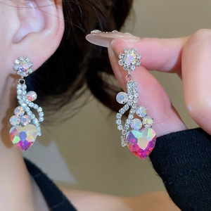 Detail of crystal heart earrings with sparkling floral diamond accents in silver finish