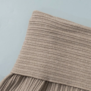 Close-up detail of beige rib-knit fabric texture on long sleeve off-shoulder dress