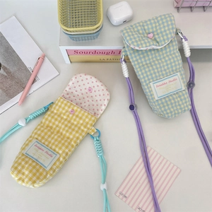 Close-up of quilted cotton camera pouch with checkered patterns and soft rope shoulder strap
