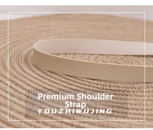Detailed macro view showing the textured beige leather shoulder strap of a woven backpack