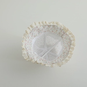 Detail showing baby sun hat with delicate beige lace trim and pink floral lining pattern