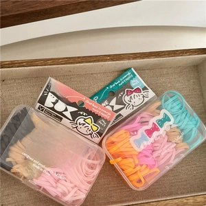 Detail of four boxes of colorful high-elastic hair ties in cute cartoon packaging