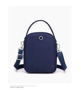 Detail view of navy blue nylon crossbody bag with earphone port and adjustable strap