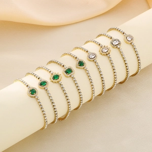 Detail of vintage gold plated titanium bracelets with emerald and white zircon gemstones