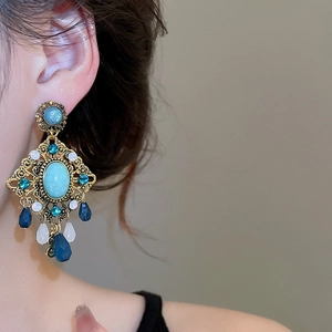 Detail of vintage bohemian drop earrings with turquoise stone and blue crystal beads