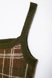 Macro detail of dark green plaid knit camisole showing shoulder strap and fabric texture