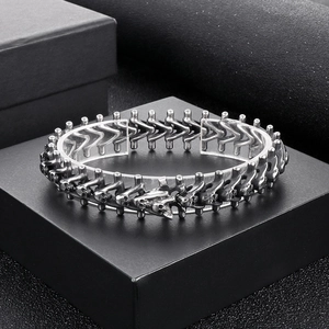 Macro detail of gothic spinal bone links and skull engravings on vintage steel bracelet