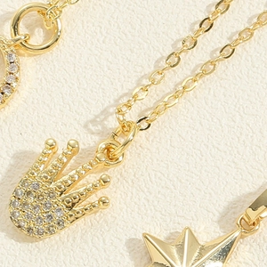 Détail macro de pendentifs couronne et étoile dorés avec des pierres de zircon