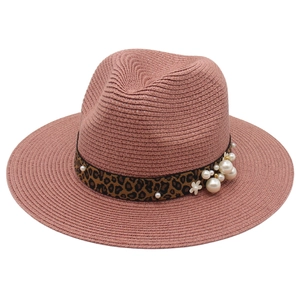 Close-up of pink Panama hat with leopard print band, pearls and white floral accents