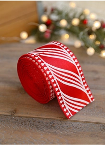 Detail of red and white Christmas ribbon roll on a wooden table with festive lights
