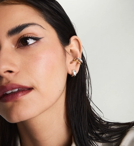 Close-up of dual-tone gold and silver S925 sterling silver ear cuffs worn on the ear