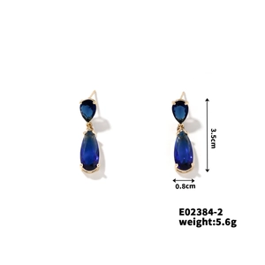 Detail view of gold drop earrings with dark blue zircon and size measurements