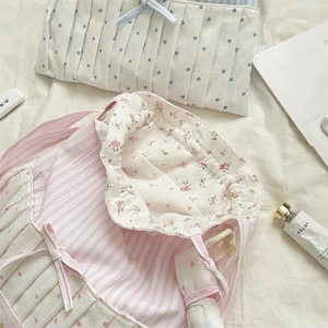 Detailed close-up of pink striped drawstring tote bag with sweet bow and floral lining