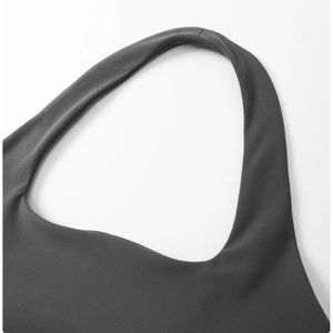 Détail des bretelles croisées et du tissu élastique sur le soutien-gorge de sport gris
