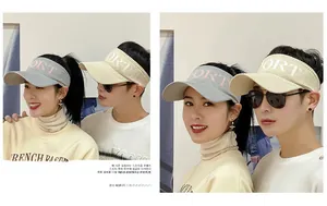 Detail view of breathable sport sun visors in grey and beige with SPORT lettering