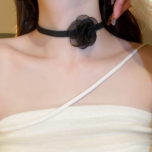 Detailed view of an elegant black mesh flower choker on neck with ribbon detail