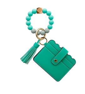 Close-up of mint green leather wallet with silicone bead wristlet and tassel detail