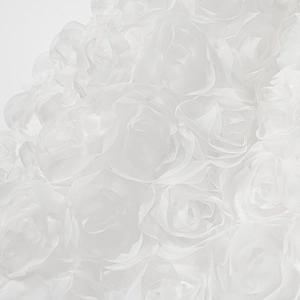 Macro shot of 3D fabric rose petals on the white strapless dress with layered texture