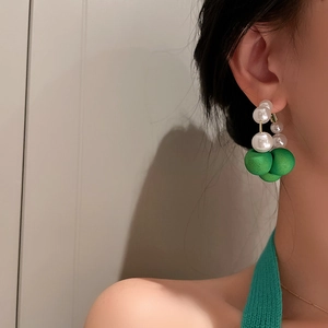 Retro round faux pearl and green acrylic hoop earrings shown on model's ear profile
