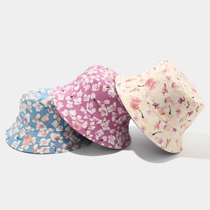 Close-up of floral bucket hats in blue, magenta, and beige with cherry blossom prints