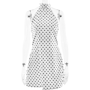 Vue détaillée d'une robe dos nu à pois blancs avec col montant sans manches et coupe ajustée