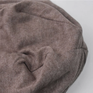Gros plan du bonnet en tricot marron montrant la texture côtelée douce et le coton chaud