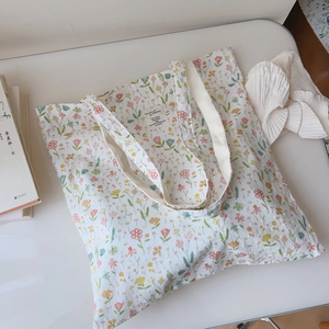 Close-up of floral cotton tote bag with vintage woven label and durable canvas straps