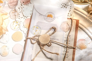 Detail of vintage-style gold foiled wax seal stickers with ginkgo and floral patterns