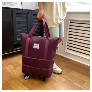 Purple expandable travel bag with wheels shown in use by a model in a home setting