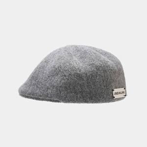 Detail shot of a grey wool beret featuring the JISIZAN.LING brand label on the side