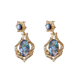 Vintage oval shell earrings with gold metal hollow patterns and blue purple stones