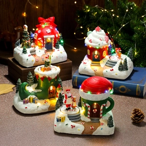 Detail view of resin Christmas music boxes with warm LED lights and miniature houses