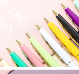 Detailed macro view of vibrant multi-color retractable ballpoint pens with gold clips