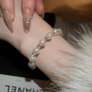 Close-up of double-layered pearl bracelet with sparkling rhinestones on female wrist
