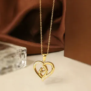Detailed close-up of golden titanium steel heart necklace with mother and child pendant