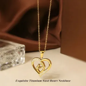 Detailed close-up of golden titanium steel heart necklace with mother and child pendant
