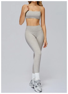 Close-up of high-waist yoga leggings and sports bra set in heather grey fabric texture