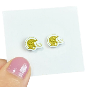 Detailed view of shiny gold football helmet stud earrings on a white square card