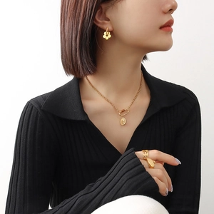 Elegant 18K gold plated jewelry set featuring flower earrings and wing ring on model