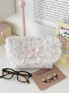 Detail of floral quilted crossbody bag with delicate lace trim and pink satin bow