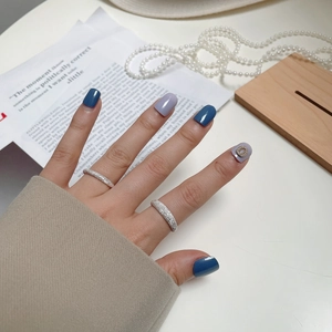 Press-on nails in navy blue and dusty purple with rhinestones and silver rings