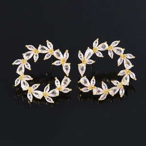 Luxurious C-shaped gold-plated hoop earrings with sparkling zircon floral patterns on black background