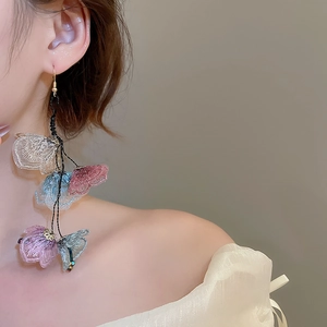 Detail of floral lace tassel earrings worn by model for a bohemian vacation look